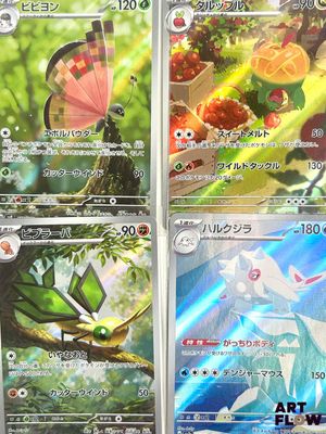 Quatre cartes Pokémon sont posées sur une table dans une pièce.