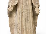 an old statue of a woman in a white robe and a hat