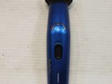 a blue electric shaver on a white surface