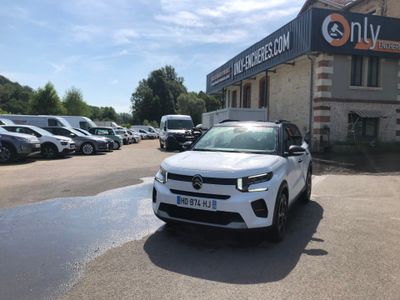 a white car parked in front of a building with cars parked in front of it