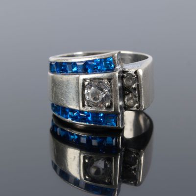 a close up of a silver ring with blue and white stones