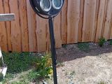 une photo d'un projecteur noir dans un jardin