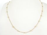 un collier en chaîne d'or orné de perles sur un mannequin