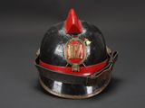 an old fireman ' s helmet with a red and black band