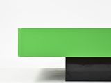 a close up of a green table with a black base