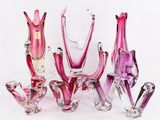 un ensemble de vases en verre rose disposés les uns à côté des autres