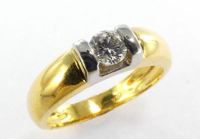 gros plan d'une bague en diamant sur une surface blanche