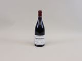 une bouteille de vin posée sur une table blanche
