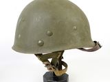 an image of a green helmet on a black base on a white background