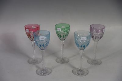 four different colored wine glasses sitting next to each other on a white surface
