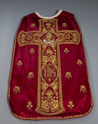 a close up of a red and gold robe with a cross on it