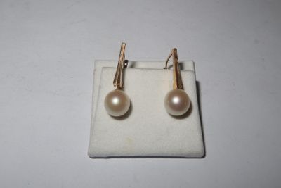 pair of pearl and gold earrings on a white cloth