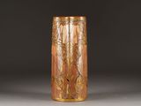 a vase that has a gold decoration on it