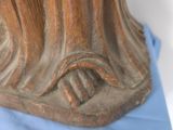 a close up of a wooden statue on a blue cloth