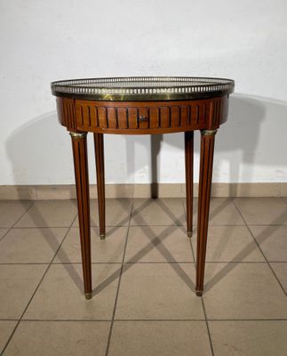 a small table with a glass top on a tiled floor