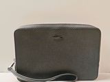 un gros plan d'un sac à main noir posé sur une surface blanche