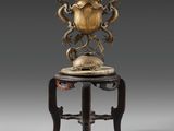 une image d'un vase en bronze posé sur une table en bois