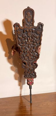 une horloge en bois posée sur un socle, sur un parquet