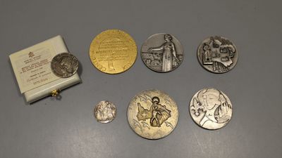 plusieurs pièces d'argent et d'or ainsi qu'une petite boîte posées sur une table