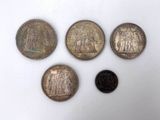 four different types of coins sitting on top of a white surface