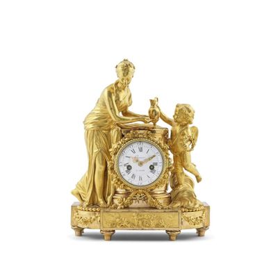 une horloge en or sur laquelle sont représentés une femme et un enfant