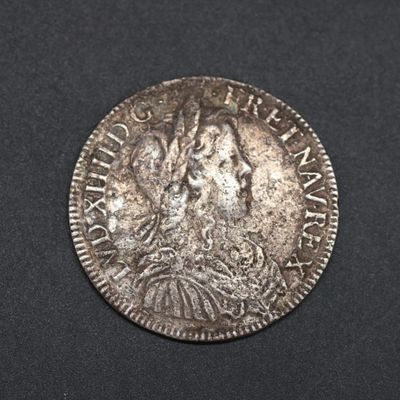 une pièce de monnaie en argent portant un visage de femme