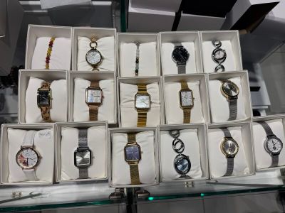 many different watches in a display case on the table