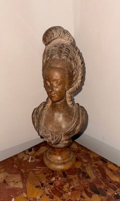 un buste de femme posé sur un socle dans une pièce