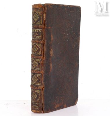 un vieux livre posé sur une table à côté d'un fond blanc