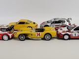 several toy cars are lined up in a row on a white surface