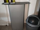 a trash can sitting next to a trash can in the corner of a room
