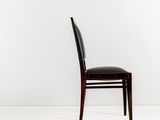 the back of a black leather chair against a white wall
