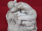 statue représentant un homme en train d'enlacer une femme sur fond rouge