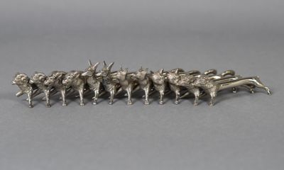 a silver figurine of a herd of cattle