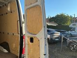 une camionnette blanche dont la porte est ouverte et dans laquelle se trouve un vélo à l'arrière