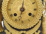 a gold clock sitting on top of a black table
