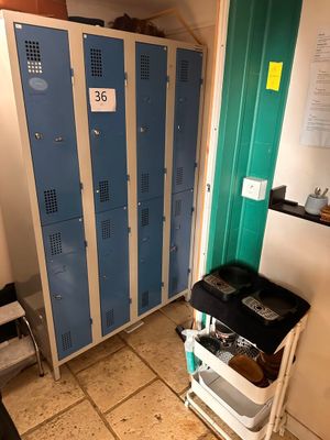 two lockers in a room with a cart in front of them