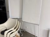 three chairs and a white board in the corner of a room