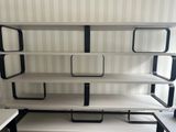 a white shelf with black shelves on it in a room