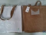 un sac marron et un sac blanc posés sur une table