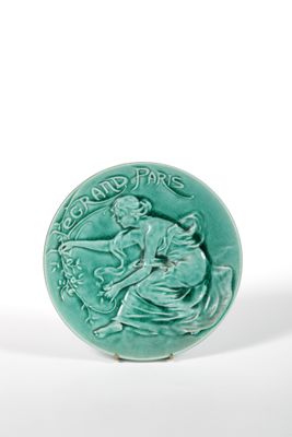 an image of a green ceramic button with a woman on a horse
