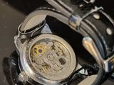 a close up of a watch on a black surface
