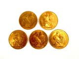 four gold coins sitting on top of each other on a white surface