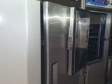 several stainless steel refrigerators are lined up in a room