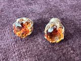 pair of orange crystal earrings on a purple cloth