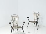 une paire de chaises en métal dans une pièce blanche au sol blanc
