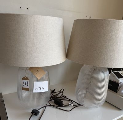 deux lampes posées sur une table, avec un ordinateur portable à l'arrière-plan