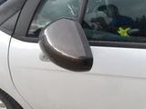a white car with a black side mirror and a yellow sticker on the window