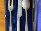 a silverware set in a blue case on a wooden table