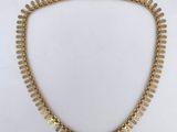 a gold necklace on a white background